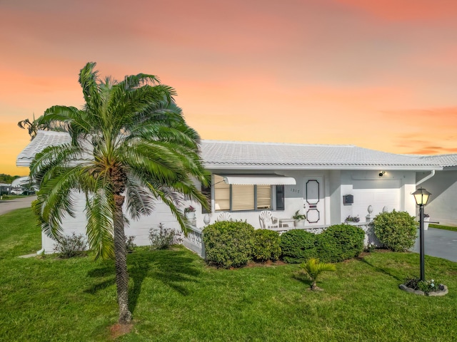 view of front of house featuring a lawn, an attached garage, and stucco siding