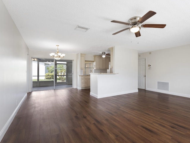 unfurnished living room with baseboards, dark wood-style floors, visible vents, and ceiling fan with notable chandelier