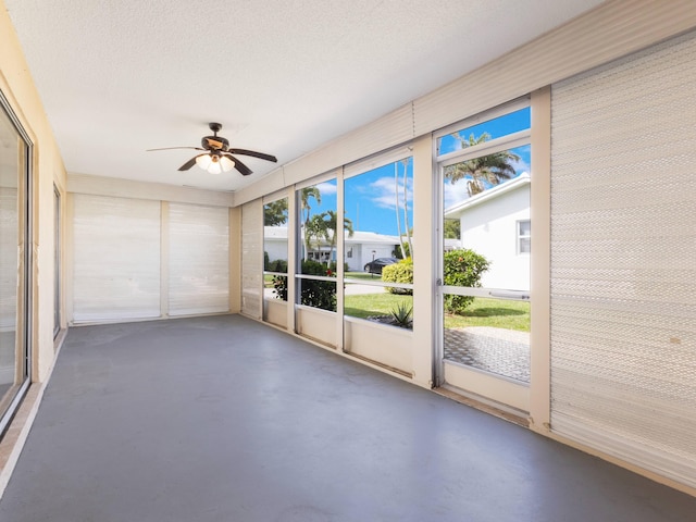 unfurnished sunroom with a ceiling fan