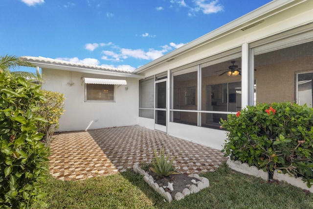 exterior space featuring stucco siding, a sunroom, and a patio area