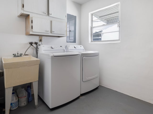 washroom featuring washing machine and dryer, electric panel, and cabinet space