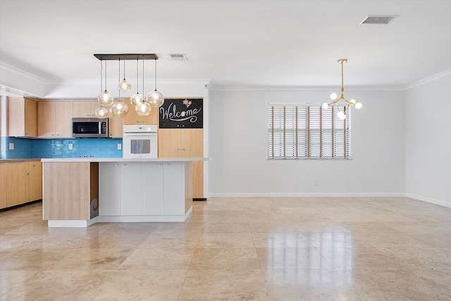 4800 Harrison St, Hollywood, FL 33021 - kitchen with white oven, stainless steel microwave, a chandelier, crown molding, and light brown cabinetry