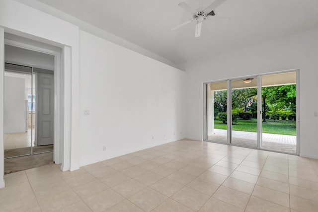 empty room with light tile patterned floors, a ceiling fan, and lofted ceiling