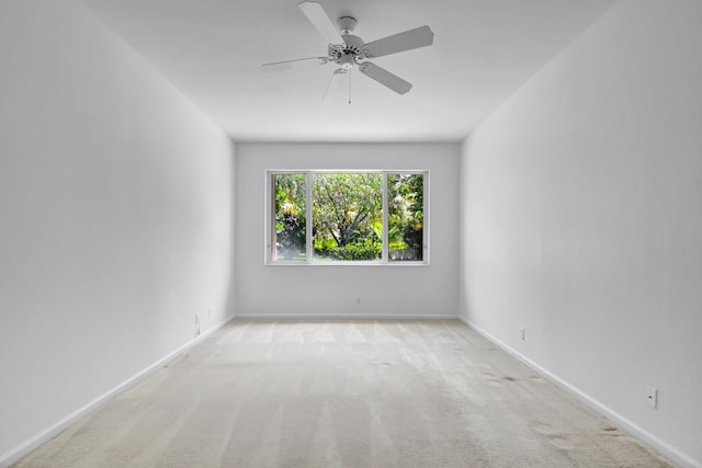 empty room featuring baseboards, a ceiling fan, and carpet