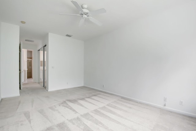 empty room featuring light carpet, baseboards, a ceiling fan, and visible vents