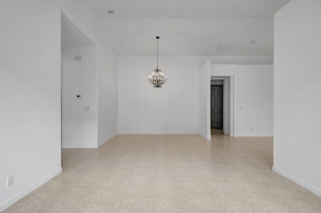unfurnished room with an inviting chandelier