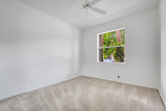 carpeted empty room featuring baseboards and a ceiling fan