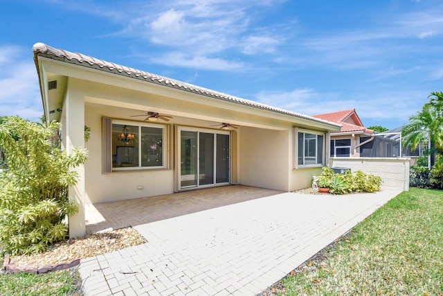 back of property with a patio, stucco siding, a tiled roof, and ceiling fan
