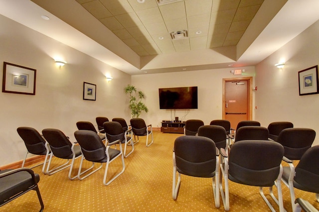 cinema room featuring a tray ceiling, carpet flooring, baseboards, and visible vents