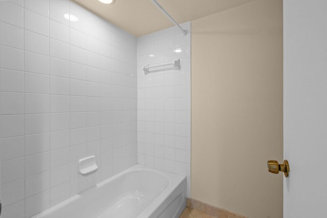 bathroom featuring tile patterned floors, bathing tub / shower combination, and baseboards