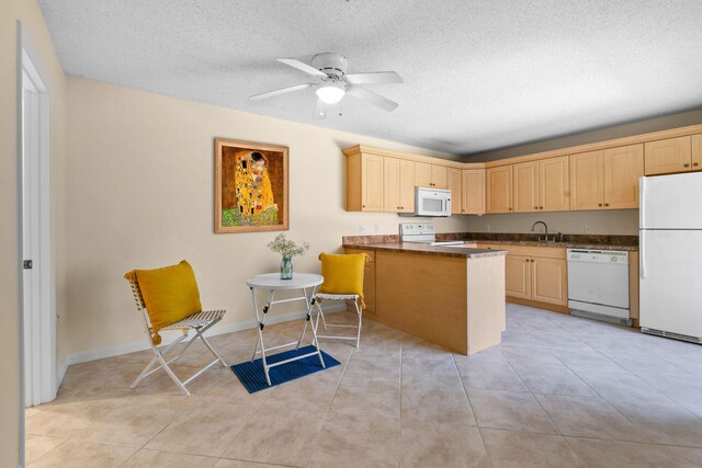 kitchen featuring white appliances, a peninsula, dark countertops, a textured ceiling, and a ceiling fan