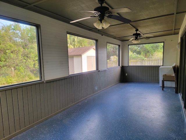 unfurnished sunroom with ceiling fan