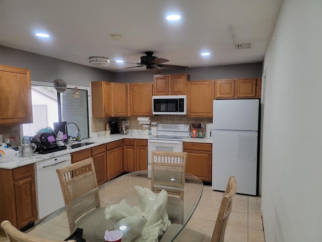 kitchen with light countertops, visible vents, white appliances, a ceiling fan, and a sink