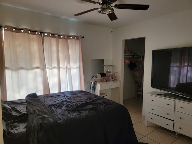 bedroom with light tile patterned flooring, a closet, ceiling fan, and a spacious closet