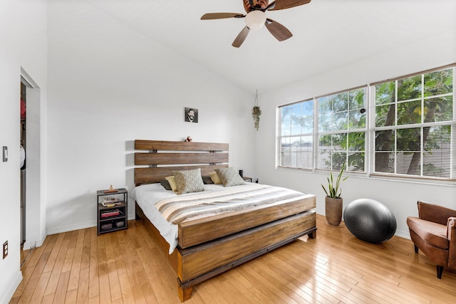 bedroom with light wood-style flooring, multiple windows, and vaulted ceiling