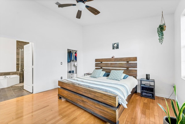 bedroom featuring hardwood / wood-style floors, a closet, a spacious closet, and a towering ceiling
