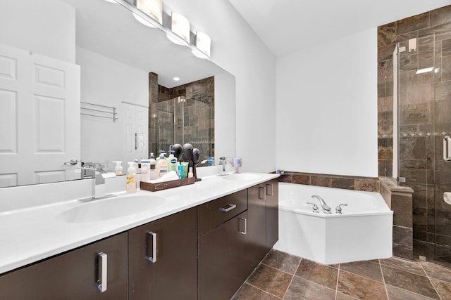 full bath with double vanity, a sink, a garden tub, and a shower stall