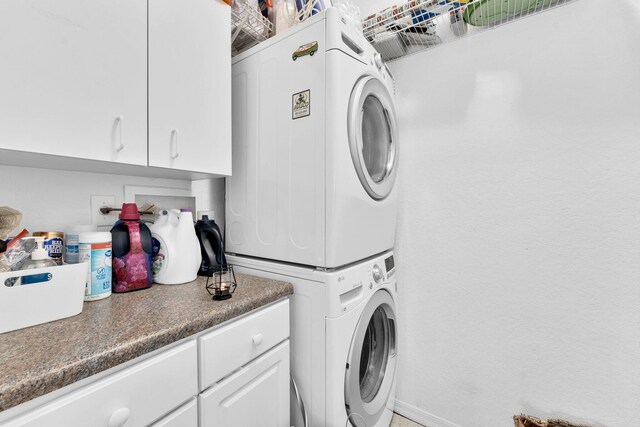 laundry room with stacked washer and dryer and cabinet space