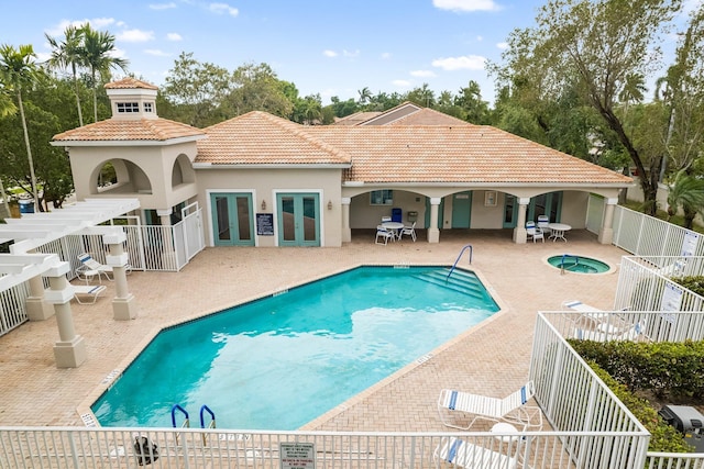 pool with stairway, fence, a hot tub, french doors, and a patio area