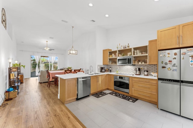 kitchen featuring light countertops, a sink, ceiling fan, a peninsula, and appliances with stainless steel finishes
