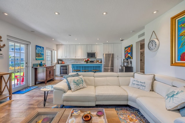1199 Hillsboro Mile Unit 119, Hillsboro Beach, FL 33062 - living room with recessed lighting, a textured ceiling, light wood finished floors, and wine cooler