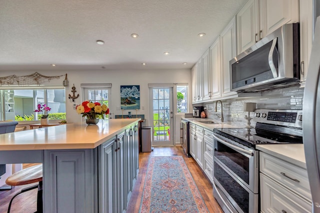 1199 Hillsboro Mile Unit 119, Hillsboro Beach, FL 33062 - kitchen featuring recessed lighting, light countertops, white cabinets, a sink, and appliances with stainless steel finishes