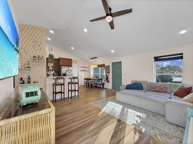 living area featuring light wood finished floors, a ceiling fan, vaulted ceiling, and recessed lighting