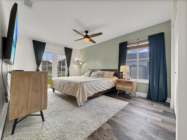 bedroom featuring french doors, visible vents, access to exterior, ceiling fan, and wood finished floors