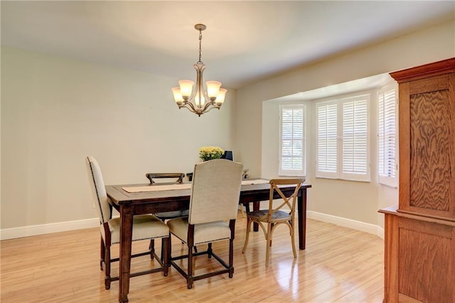 1090 31st Ave, Vero Beach, FL 32960 - dining room with baseboards, light wood-style flooring, and a chandelier