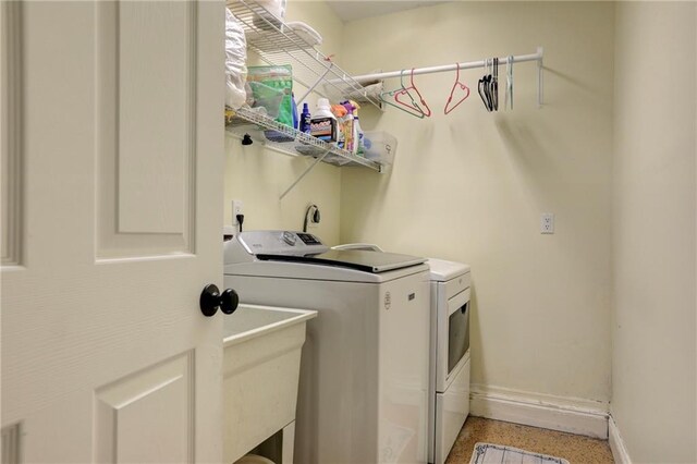 1090 31st Ave, Vero Beach, FL 32960 - laundry room with washing machine and clothes dryer, a sink, baseboards, and laundry area