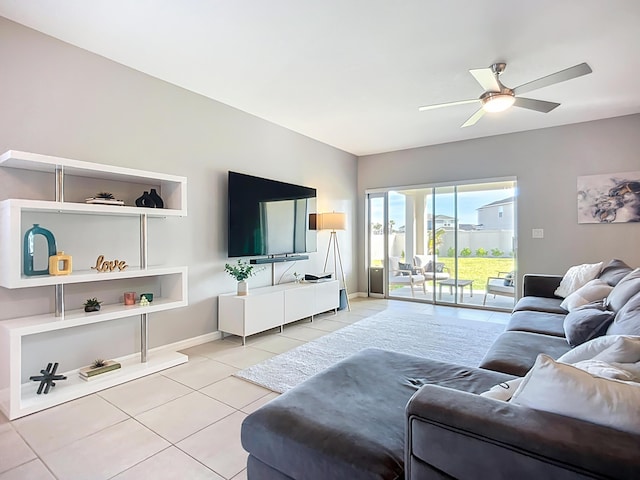 living area featuring baseboards, ceiling fan, and light tile patterned flooring