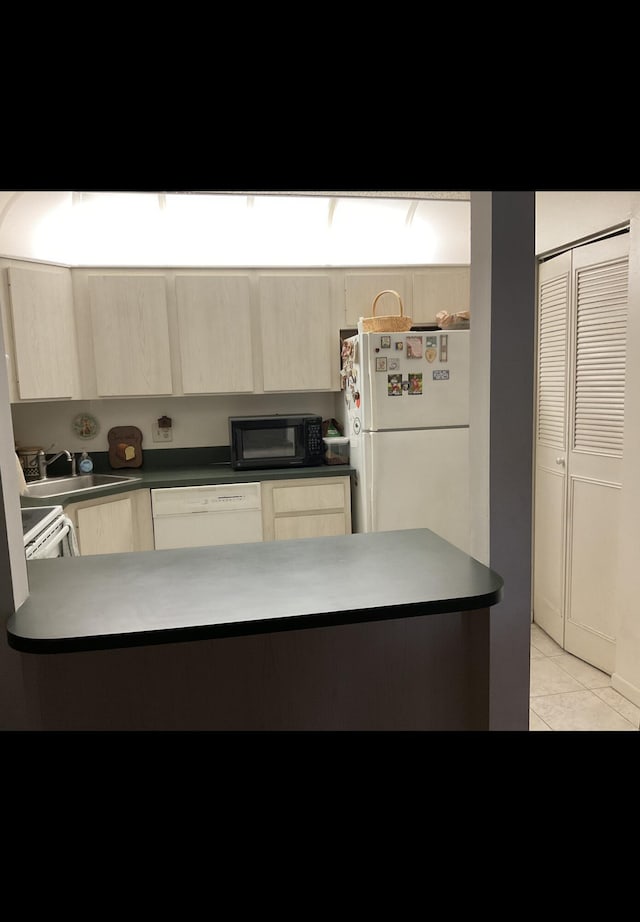 337 Knotty Pine Cir Unit B-1, Greenacres, FL 33463 - kitchen with light tile patterned flooring, a sink, light brown cabinets, white appliances, and dark countertops