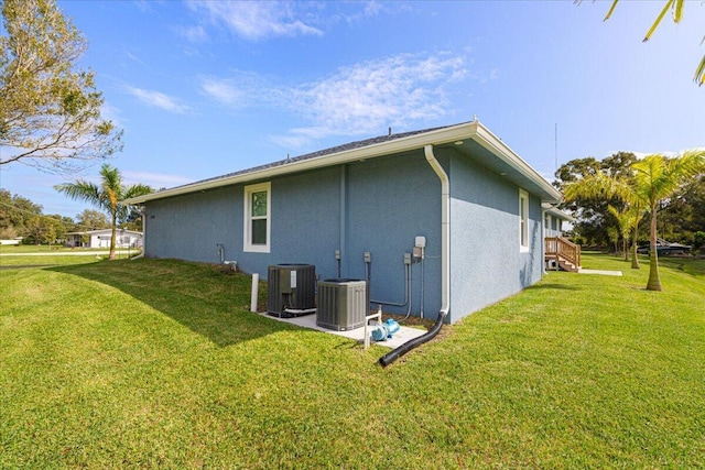 1200 Hartman Rd, Fort Pierce, FL 34947 - rear view of house with stucco siding, central AC unit, and a yard