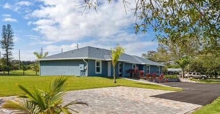 1200 Hartman Rd, Fort Pierce, FL 34947 - rear view of property featuring a lawn