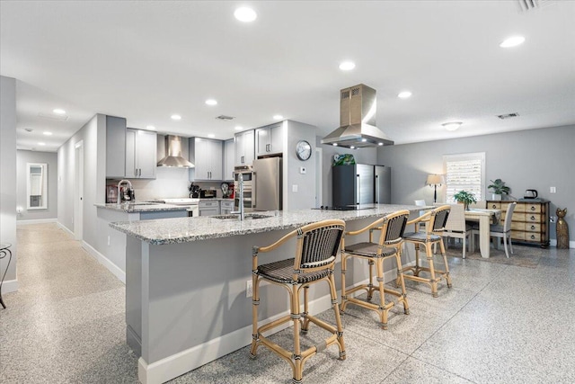 1200 Hartman Rd, Fort Pierce, FL 34947 - kitchen with island exhaust hood, gray cabinets, wall chimney exhaust hood, freestanding refrigerator, and baseboards
