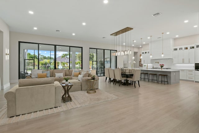 living room with visible vents, recessed lighting, and light wood-style floors