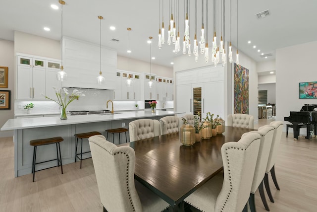dining area with light wood finished floors, visible vents, and recessed lighting