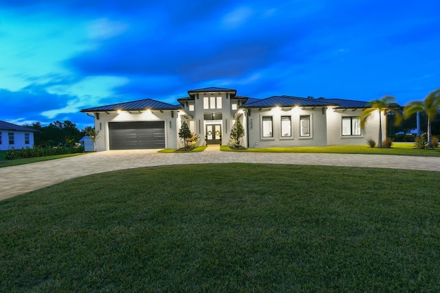prairie-style house with stucco siding, a standing seam roof, curved driveway, and metal roof