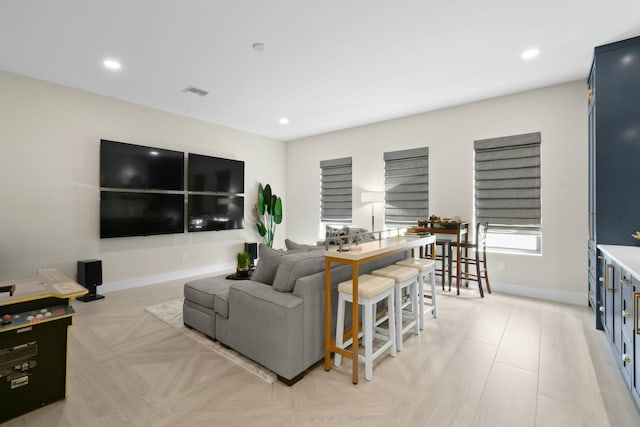 living area featuring baseboards, visible vents, and recessed lighting