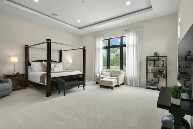 carpeted bedroom with a tray ceiling, visible vents, and recessed lighting