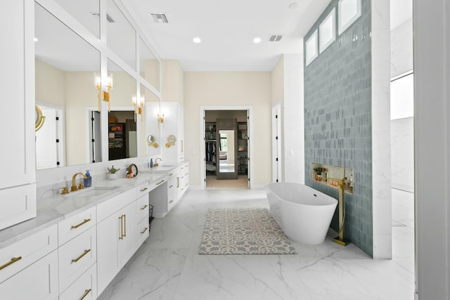full bathroom featuring a soaking tub, visible vents, tile walls, and vanity