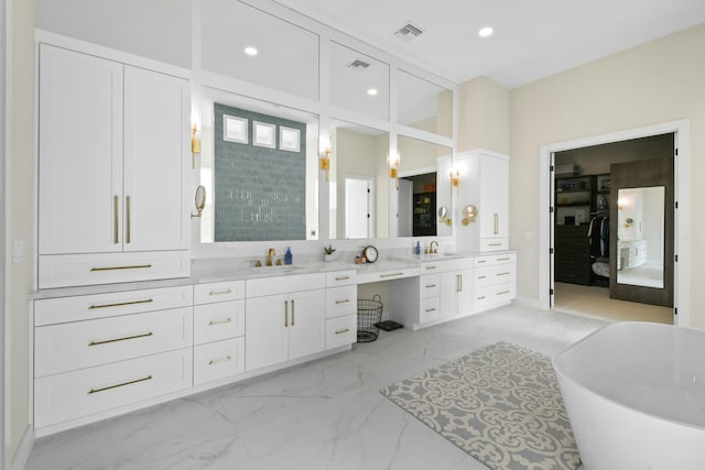 ensuite bathroom featuring marble finish floor, vanity, visible vents, and recessed lighting