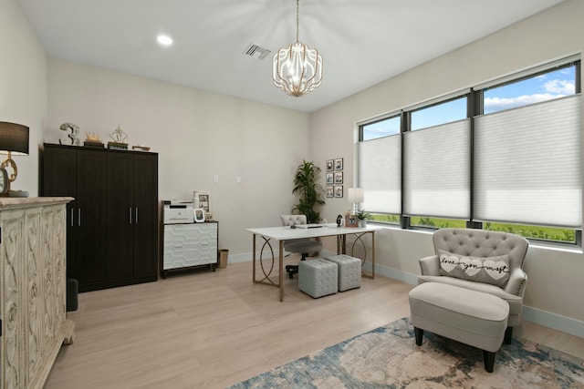 office space featuring baseboards, light wood-style flooring, visible vents, and an inviting chandelier