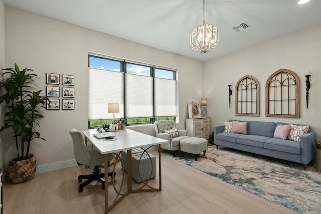office area with a chandelier, wood finished floors, visible vents, and baseboards