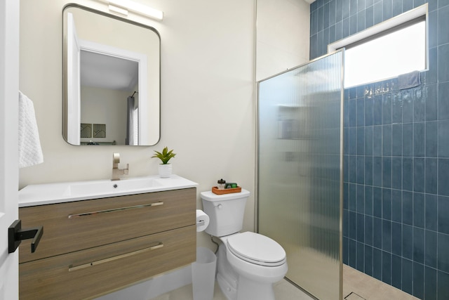 bathroom featuring toilet, vanity, and tiled shower