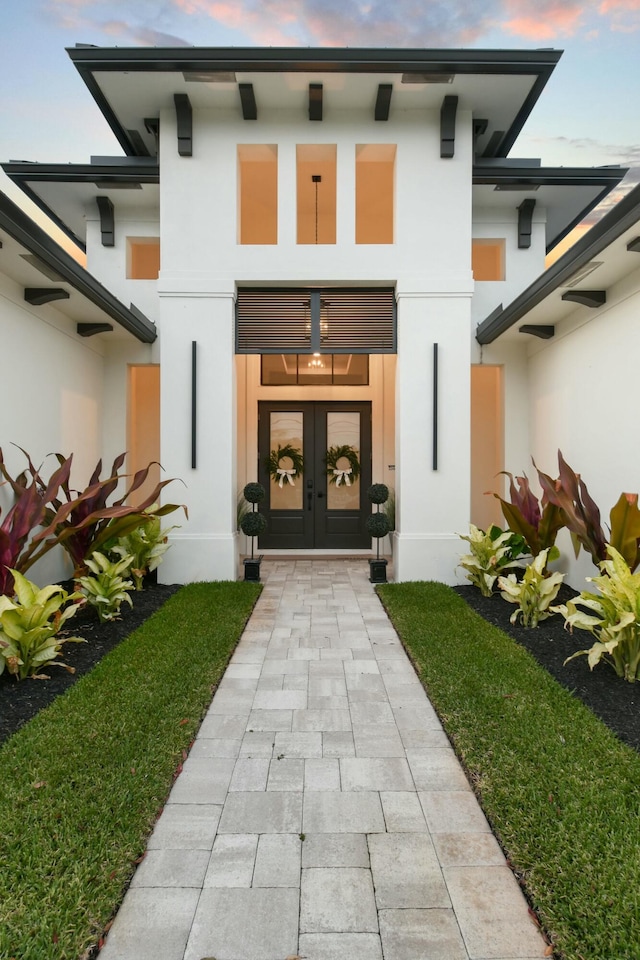 entrance to property featuring french doors and stucco siding