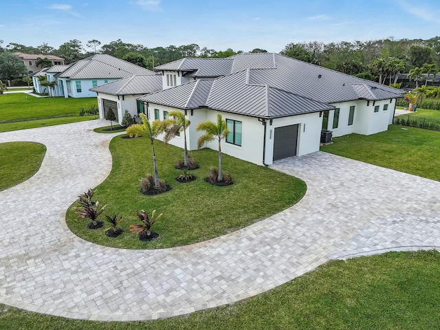 view of front facade with stucco siding, a standing seam roof, and curved driveway