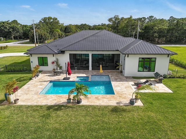 rear view of property featuring stucco siding, a yard, a fenced backyard, and metal roof