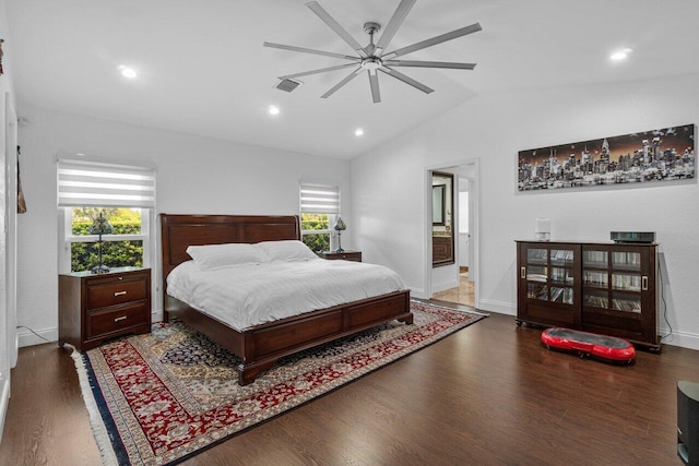 bedroom featuring lofted ceiling, wood finished floors, baseboards, ceiling fan, and connected bathroom