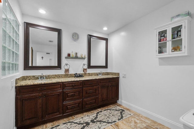 full bath with double vanity, baseboards, and recessed lighting